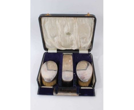 George V silver dressing table set comprising three brushes and a comb, Birmingham 1925/1926, in a fitted case.