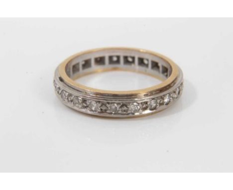 Diamond eternity ring with a band of twenty one brilliant cut diamonds set in a yellow and white metal band. Ring size K½Cond