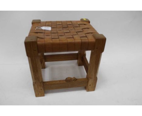Workshop of Robert Mouseman Thompson: an oak stool, strap leather top, on four octagonal legs joined by stretchers, with carv