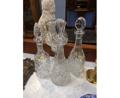 A glass hurricane lamp and three decanters