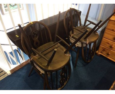A narrow Ercol oak drop leaf table and four chairs