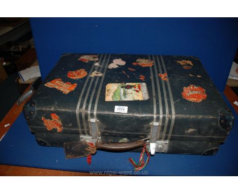 A vintage Suitcase having leather handle and travel stickers including Italy, Milan, etc.,