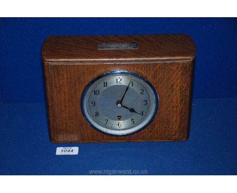 An Oak finished mantle Clock with movement marked Garrard, with key and plaque to the front 'Presented to Uncle Harry from Fr