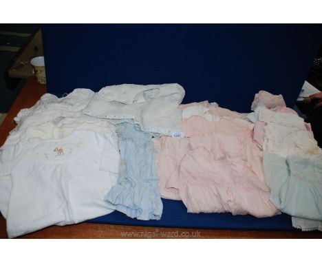 A quantity of vintage baby clothes including cotton night dresses and pink summer dresses.