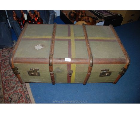 A large canvas, wooden bound Trunk with brass corners, name of ''BAIRD'' to the side.