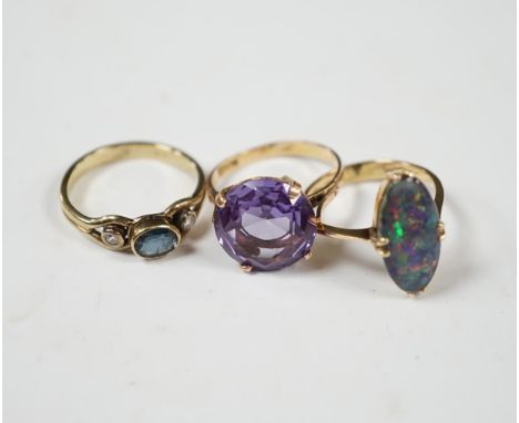 A 14k and black opal double set oval ring, size N, a yellow metal, sapphire and diamond set three stone ring and a Middle Eas