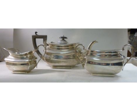 A three piece silver tea set of oval, panelled ogee form comprising a teapot with an insulated, angular handgrip, a knop to t