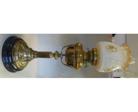 A late Victorian brass oil lamp, the twin burner in a bead bordered bowl reservoir, the supporting frame on a short, fluted s