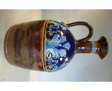 A late 19thC Doulton Lambeth blue and brown glazed stoneware whisky decanter with a narrow neck, a flared, pouring lip, strap