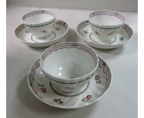 A set of three late 18thC, probably New Hall, porcelain wrythen moulded and floral decorated tea bowls and saucers