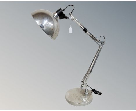 An oversized angle-poise lamp in a chrome finish 