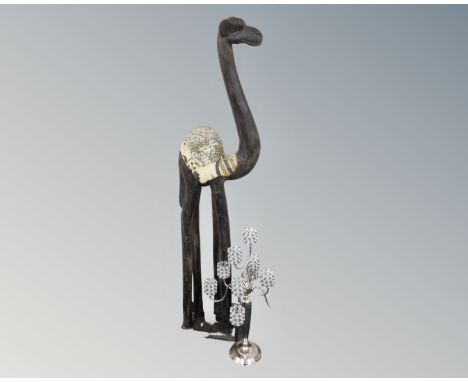 A wooden floor standing ornament depicting a camel together with a decorative metal ten-way tea light holder.