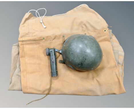 A box containing two vintage canvas duffel bags together with a military helmet and a torch.