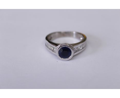 A sapphire &amp; diamond ring, stamped 750, the round sapphire measures approx 1.00ct, princess cut diamonds total approx 0.5