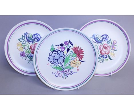 A PAIR OF POOLE POTTERY CIRCULAR PLATES decorated with a bird amongst flowers and a similar plate.