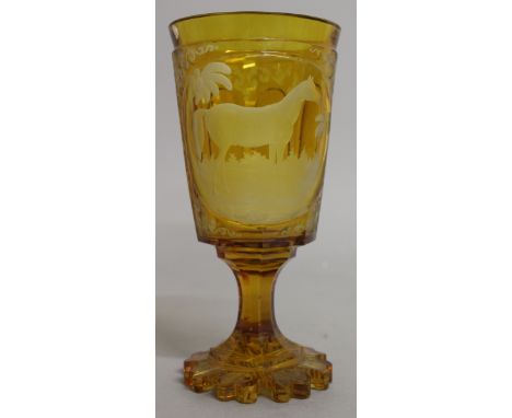 A FINE BOHEMIAN AMBER GOBLET engraved with a panel of a horse in a landscape. 7ins high.