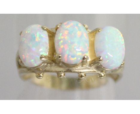 A 9CT YELLOW GOLD RING, set with three oval opals.