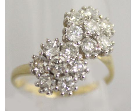 A VERY GOOD 18CT YELLOW GOLD AND DIAMOND DOUBLE FLOWER HEAD CROSSOVER RING.