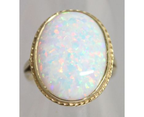 A LARGE OVAL OPAL RING, set in 9ct yellow gold.