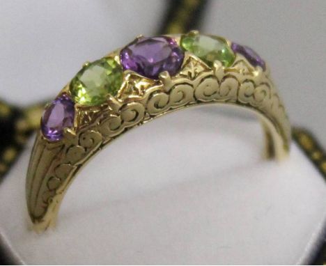 A 9CT YELLOW GOLD AMETHYST AND PERIDOT RING.