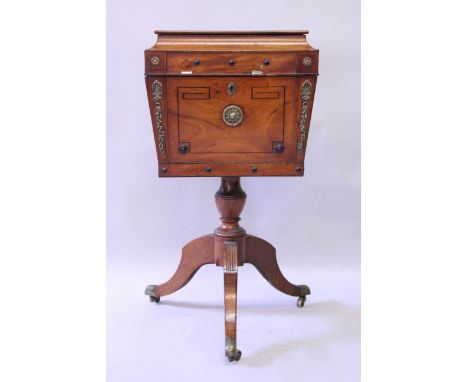 A REGENCY ROSEWOOD TEAPOY with rising top and fitted interior, centre column support ending in tripod curving legs with brass