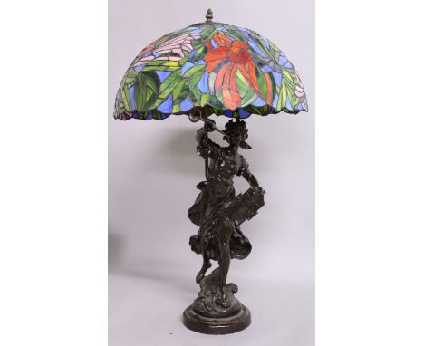 A GOOD TIFFANY STYLE LEADED LAMP, the base as a classical young lady blowing a horn. 33ins high.
