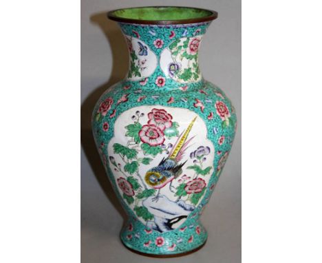 AN EARLY 20TH CENTURY CHINESE CANTON ENAMEL VASE, the sides decorated with shaped panels of birds and foliage reserved on a t