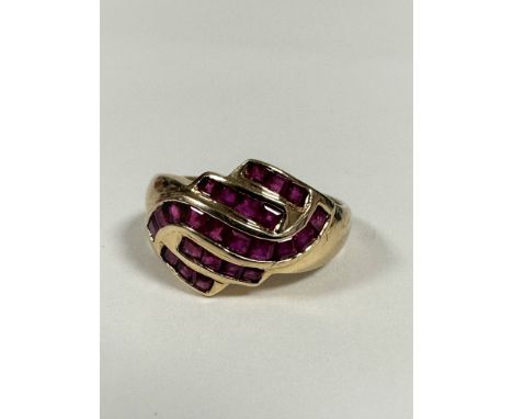 A 9ct gold scrolling calibre set ruby dress ring of scrolling form (P/Q) (3.52g)