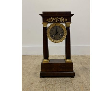 An early 20th century mahogany Portico clock, with gilt metal mounts, enclosing a silvered dial with Roman chapter ring, late