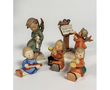 A collection of five Hummel Angel figures including two Trumpeters, Banjo player, a figure holding a candle and another with 