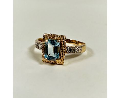 A modern 10ct gold dress ring mounted cushion cut aquamarine in yellow metal claw setting, flanked by a diamond to each shoul