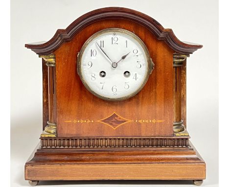 An Edwardian inlaid mahogany 8-day mantle clock, the enamel dial with black Arabic numerals flanked by two fluted columns wit