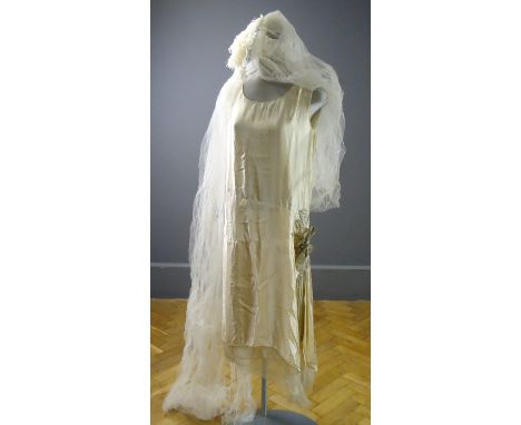 A 1920s flapper wedding dress, oyster silk with modesty sleeves, wax flower button hole, matching head piece and feathered ve