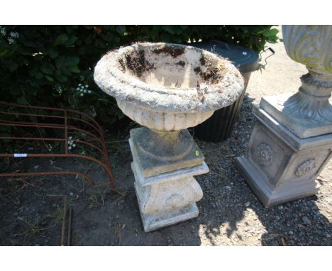 A concrete garden planter, raised on plinths