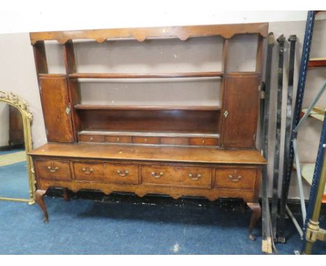 A 19TH CENTURY OAK DRESSER, the open plate rack with two cupboards and five spice drawers, the lower section with four crossb