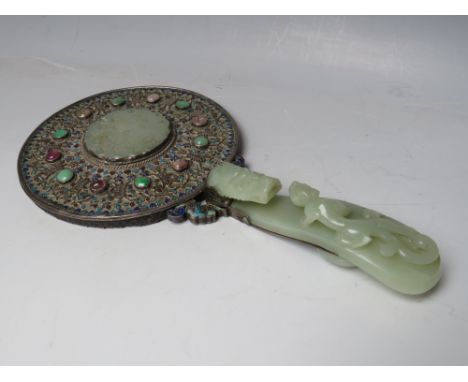 A CHINESE SILVER AND ENAMEL HAND MIRROR MOUNTED WITH JADE, the handle made from a carved jade belt hook, the mirror verso ins