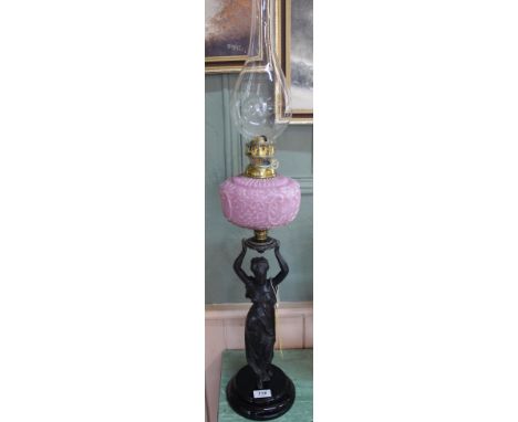 A spelter figural oil lamp with pink glass bowl