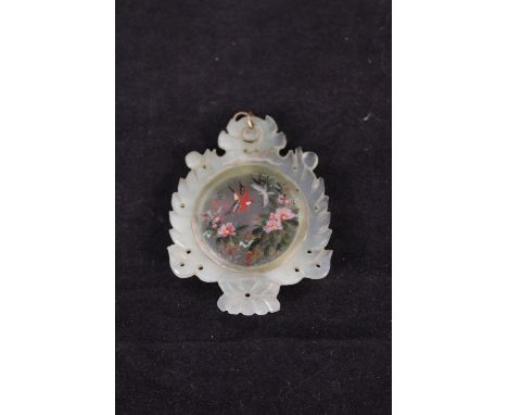 A carved jade pendant with painted bird detail