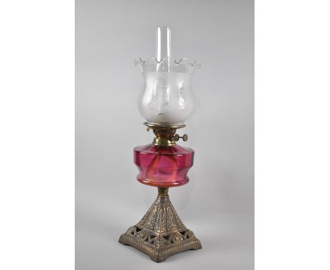 A Late Victorian Cast Metal Based Oil Lamp with Cranberry Glass Reservoir and Duplex Controls, Etched Shade and Plain Glass C