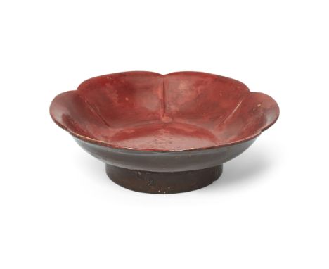 A Chinese red and brown lacquer 'prunus' dishSong dynastyThe thin vessel rising from a tall, straight foot to wide, gently ro