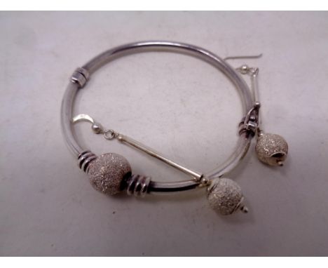 A silver bangle with matching earrings  