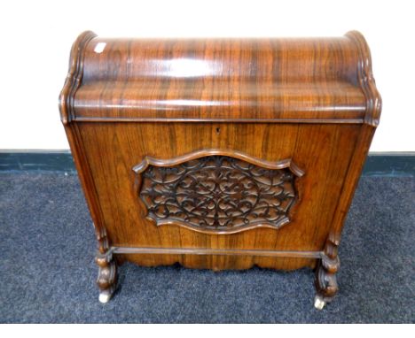 An early Victorian rosewood dome topped music cabinet, fitted divider within, raised on ceramic castors, height 53 cm 