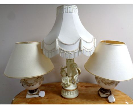 A contemporary cherub composite table lamp with tasselled shade together with a further pair of table lamps with shades   