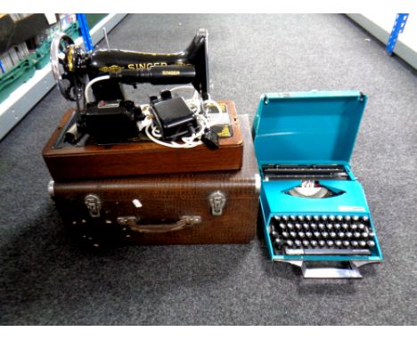 A 20th century cased Singer sewing machine with accessories (electrified) together with a Smith Corona manual typewriter in c