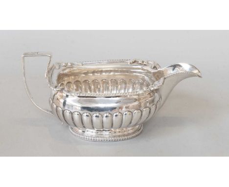 A George III Silver Cream Jug, by Nathaniel Smith and Co., Sheffield, 1808, part-fluted oval, with foliage heightened gadroon