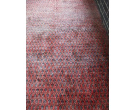 An Arrak carpet, the all-over hook medallions in pale red, blue and cream, on a pale red ground within a narrow blue and crea