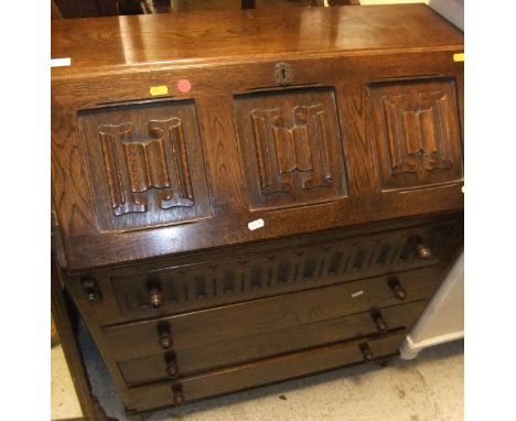 An oak bureau with linenfold decoration to the fall, a green painted pine side table, green painted bench, tambour fronted te