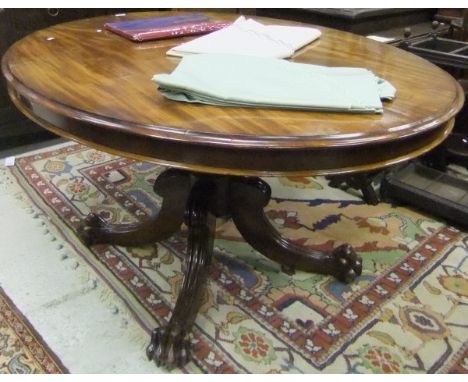 An early Victorian mahogany breakfast table, the oval snap top on a reeded baluster pedestal to hipped splayed quadruped base