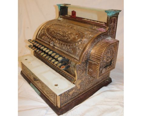 An old ornate brass National Cash Register by The National Cash Register Co of Dayton Ohio USA with raised scroll decoration 