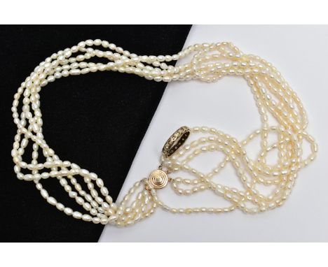 A YELLOW METAL FULL ETERNITY  RING AND A CULTURED PEARL NECKLACE, worn yellow metal full eternity band set with colourless st